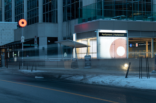 In the early morning, a long exposure bus passes by the downtown Ottawa OC Transpo station, Parliament. OC Transpo is public transport in Canada's capital.