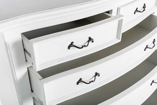 open drawer in a wooden cabinet of furniture, accessories shot close-up