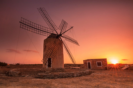 A gold sunset in windmill of La Mola in the balearic island of Formentera.