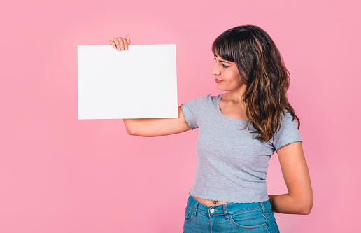 Woman holding a blank sign against a pink background