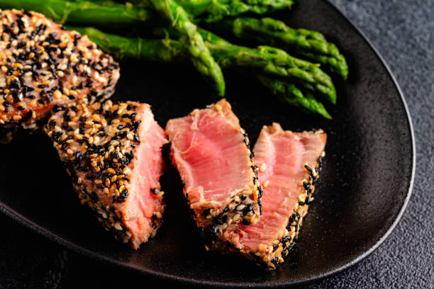 istock Tuna steak fried in sesame seeds served with asparagus. 1642630248