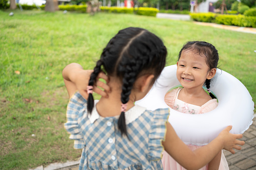 Two little girls playing happily on the grass