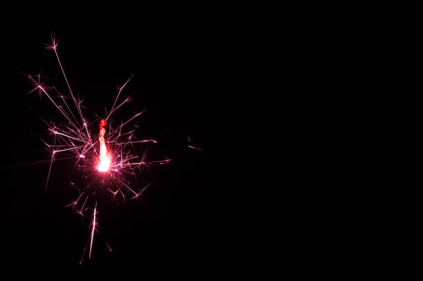 istock Sparkler in pink and white light on a black background. 1642647548