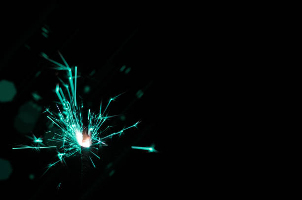 istock Sparkler in turquoise and white light on a black background. 1642648659
