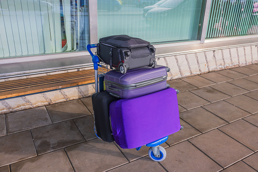 Close-up view of suitcases on trolley near airport entrance. Concept of tourism and transport.