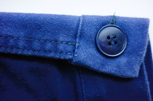 close up of blue jacket sleeve and button
