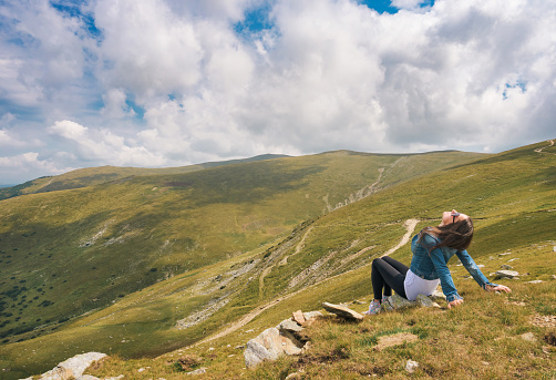 A young woman travels in a mountainous area and enjoys the spectacular scenery