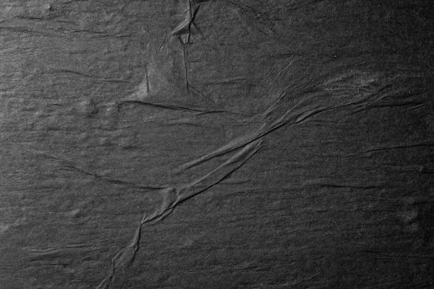 istock Black paper background with folds close up. 1642771210