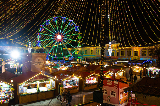 View of the Christmas Market with the Ferris Wheel and kiosks in Sibiu, Romania