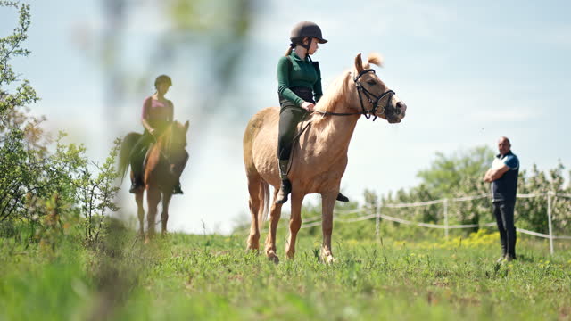 Girls training riding horses
