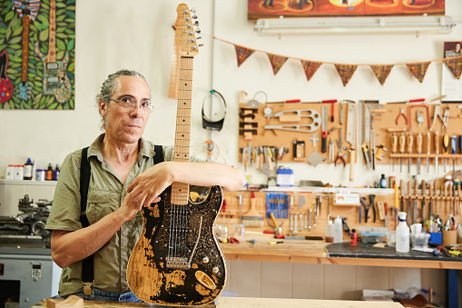 Portrait with copy space of an aged Luthier in the workshop