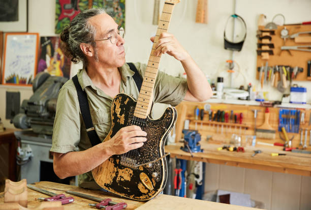 istock Middle-aged luthier playing a handmade electric guitar in his workshop. 1642792508