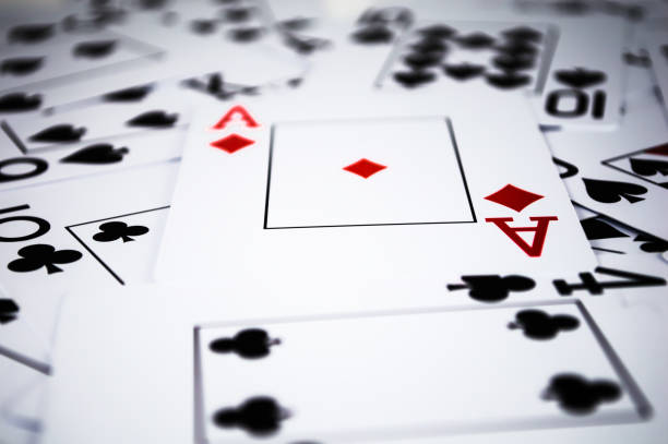 istock Black playing cards with one red card in chaos 1642813050
