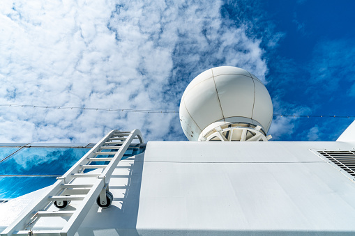 white antennas, radar and other communication and navigation equipment on the mast of ship