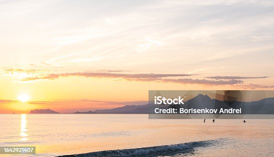 istock Sunrise over the sea, in the background people are swimming in the sea and a mountain in a haze. San Juan beach Alicante Spain. 1642921407