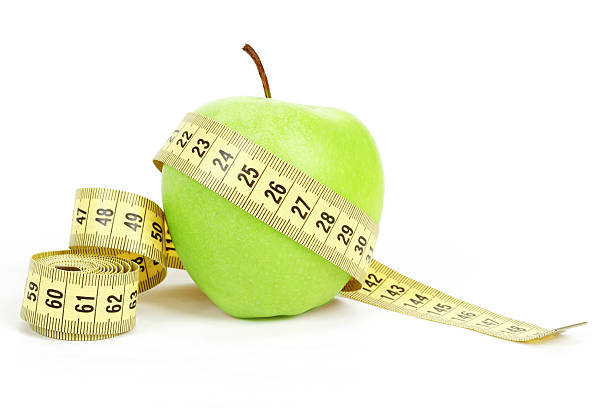 istock Green apple and measuring tape isolated on white background 164297924