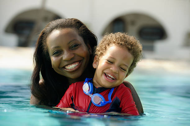 малыш и родителей, наслаждаясь плавательный бассейн - baby1 стоковые фото и изображения
