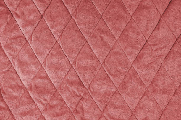 istock Quilted red velours fabric background, wrinkled soft blanket surface 1643044362