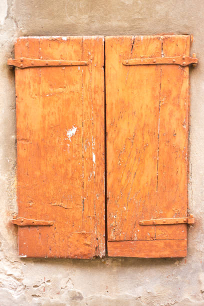 Crémieu, France: Weathered Orange Wood Shutters Close-Up
