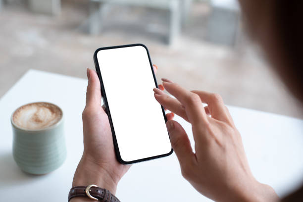 istock Mockup, woman's hand holding using mobile phone at coffee shop with copy space, white blank screen for text, mobile app design and advertsing, online marketing 1643199892