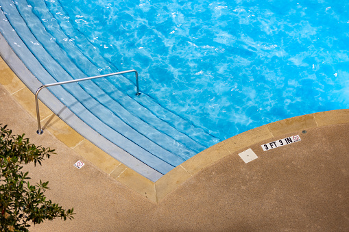 Edge of swimming pool with No Diving warning sign and 3 ft depth marker