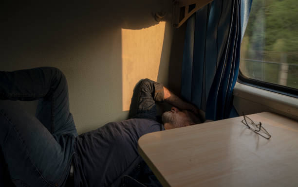 Caucasian man lying on bed in train. China
