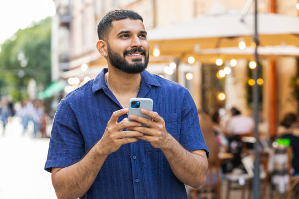 istock Indian man use smartphone typing text messages browsing internet finishing work chatting online 1643264264