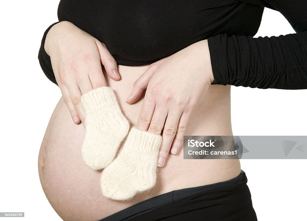 Mujer manos sosteniendo bebé calcetines - Foto de stock de Abdomen libre de derechos