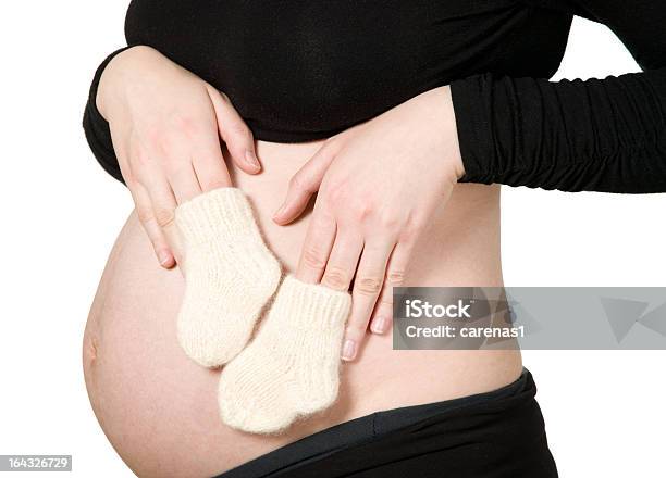 Mujer Manos Sosteniendo Bebé Calcetines Foto de stock y más banco de imágenes de Abdomen - Abdomen, Abdomen humano, Adulto