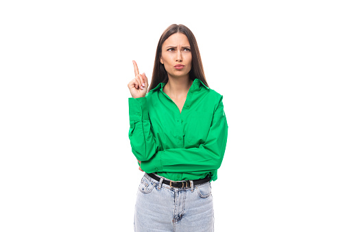 portrait of a smart pensive slim cute brown-eyed brunette woman dressed in a green shirt smiling on a white background with copy space.