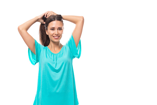 portrait of a pretty young caucasian brunette woman in a blue t-shirt on a white background with copy space.