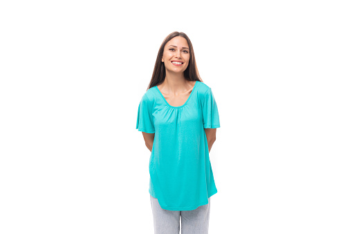 30 year old attractive brunette woman with flowing straight hair put on a blue T-shirt and jeans.