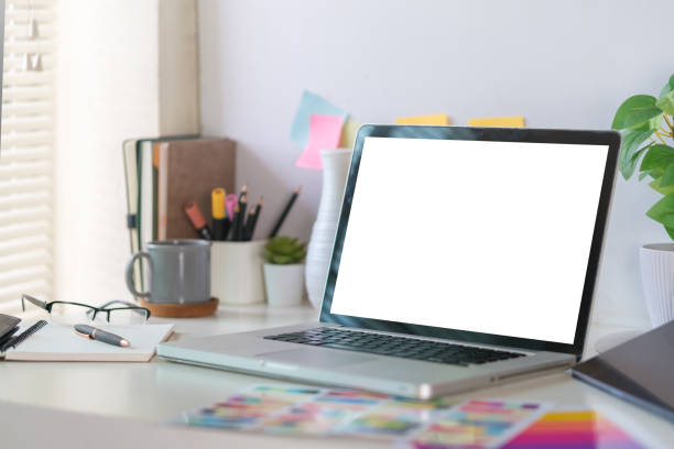 istock Comfortable home office. Laptop computer, stationery and potted plant on white table. 1643297911