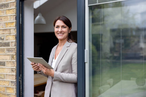 istock Happy real estate agent using a tablet while showing a property 1643299991