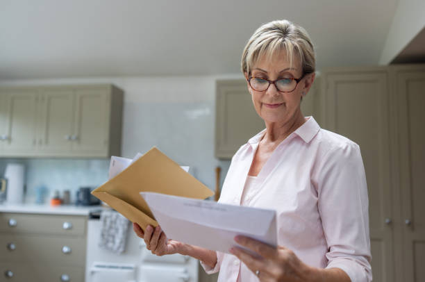 istock Senior woman at home checking her mail 1643301050