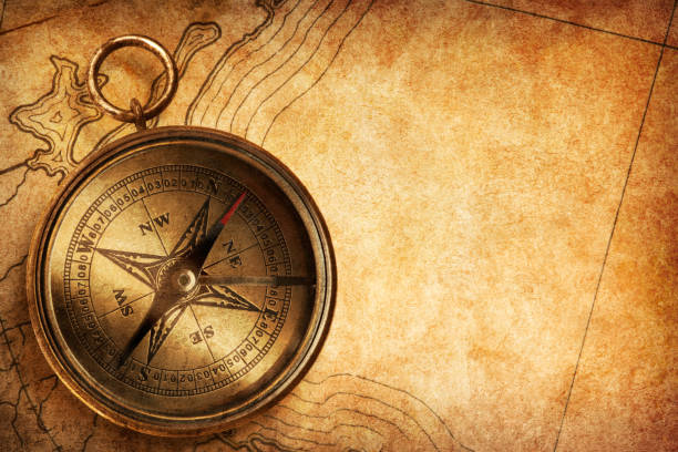 Compass Sitting On An Old Textured Map - fotografia de stock