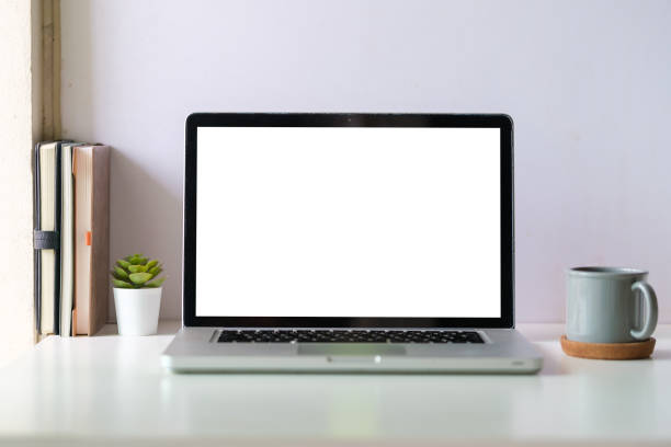 istock White working desk with laptop, coffee cup and books. Modern workspace, blank screen for your advertise text. 1643302098