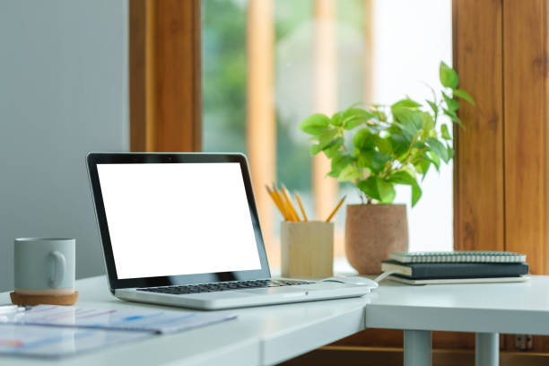 istock Computer laptop with empty display on wooden table in modern office. 1643302652
