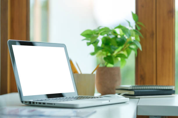 istock Comfortable home office. Laptop computer, stationery and potted plant on white table. 1643303158