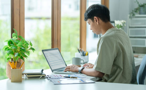 istock Side view of concentrated asian man investor analyzing online data market on laptop computer. 1643304785