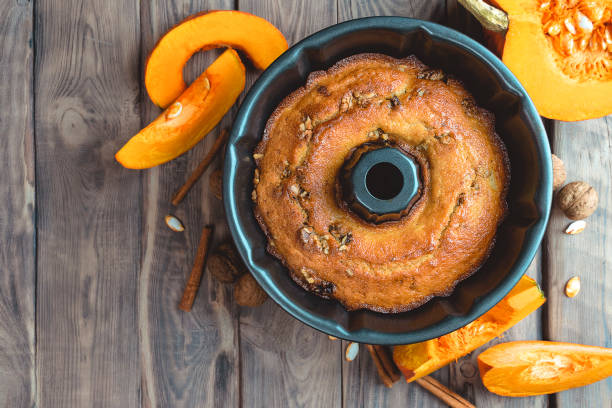 Autumn baking food background with pumpkins, apples, honey, nuts and seasonal spices on table. Pumpkin or apple pie for Thanksgiving and autumn holidays.Copy space. Traditional autumn seasonal recipes