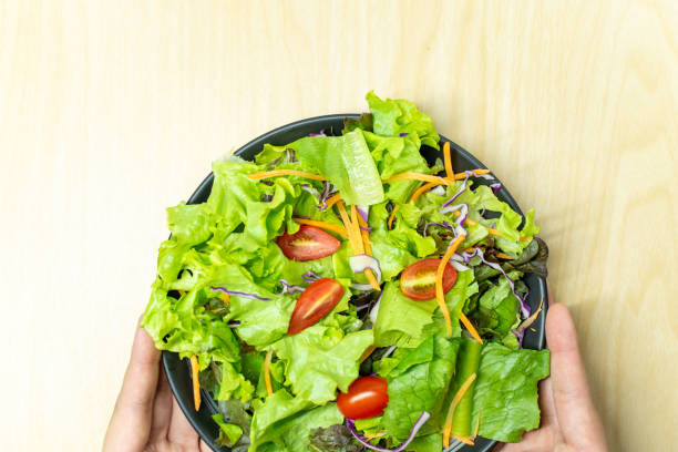istock A male employee is skillfully serving a fresh salad. 1643322199