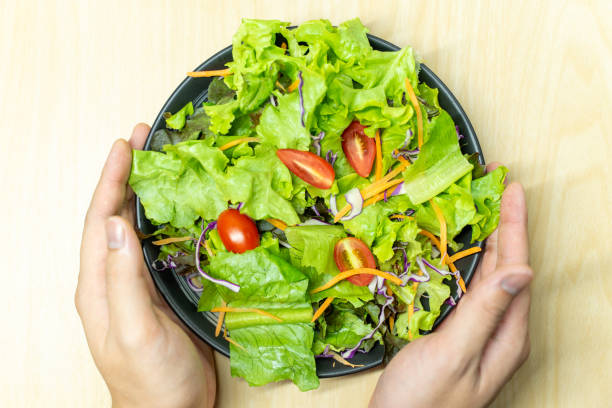 istock A male employee is skillfully serving a fresh salad. 1643322791
