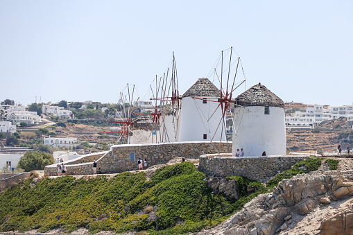 Mykonos, Greece - July 21, 2023: The iconic windmills and surrounding buildings along the shores of Mykonos Town in Greece
