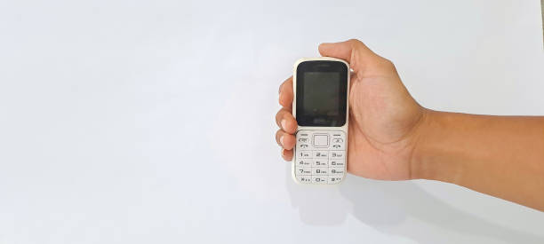 istock hand hold White old handphone on white background. This phone has a classic design before the smartphone era 1643345061