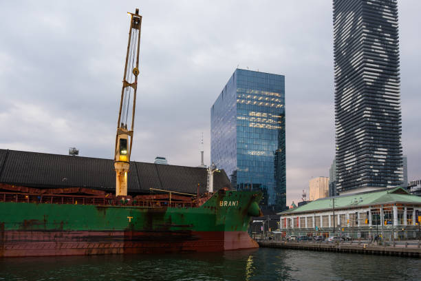 redpath sugar refinery: navio graneleiro enferrujado atracado na orla de toronto, em frente a arranha-céus modernos - toronto waterfront commercial dock canada - fotografias e filmes do acervo