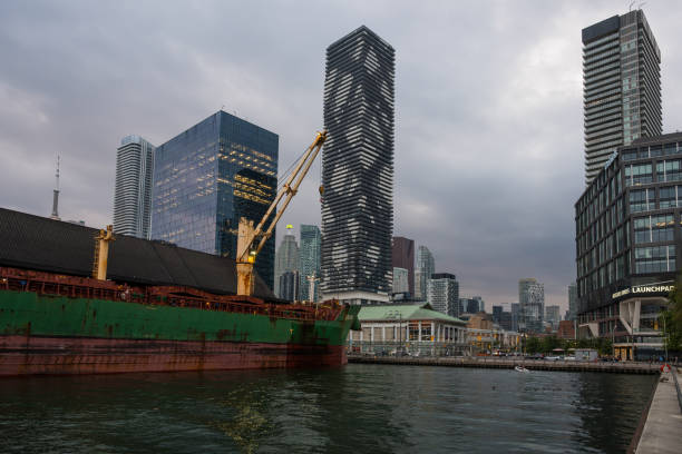 redpath sugar refinery: navio graneleiro enferrujado atracado na orla de toronto, em frente a arranha-céus modernos - toronto waterfront commercial dock canada - fotografias e filmes do acervo