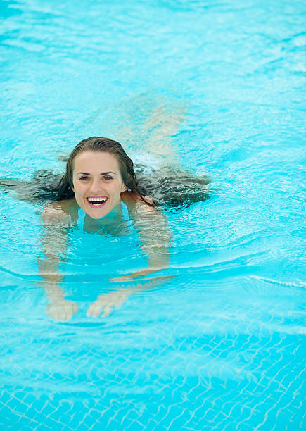 istock Happy young woman swimming in pool 164339893