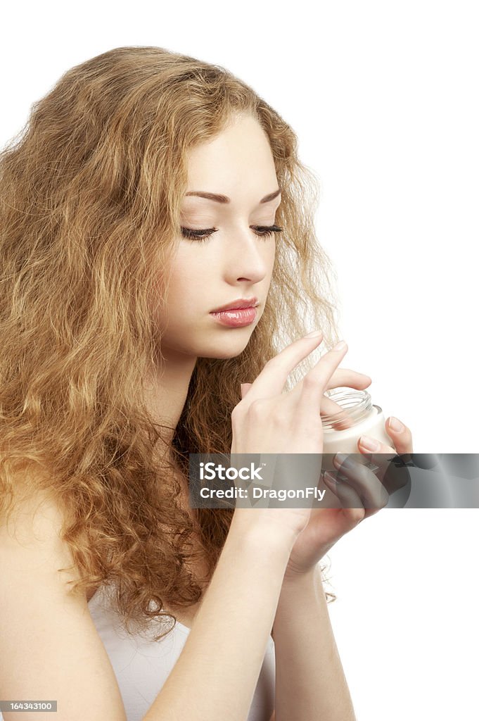 Mujer con crema de moisturizing frasco - Foto de stock de 20 a 29 años libre de derechos