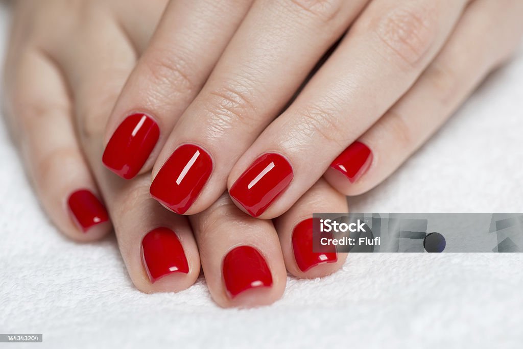 Manicure Beautiful manicured woman's hands with red nail polish on soft white towel. Adult Stock Photo